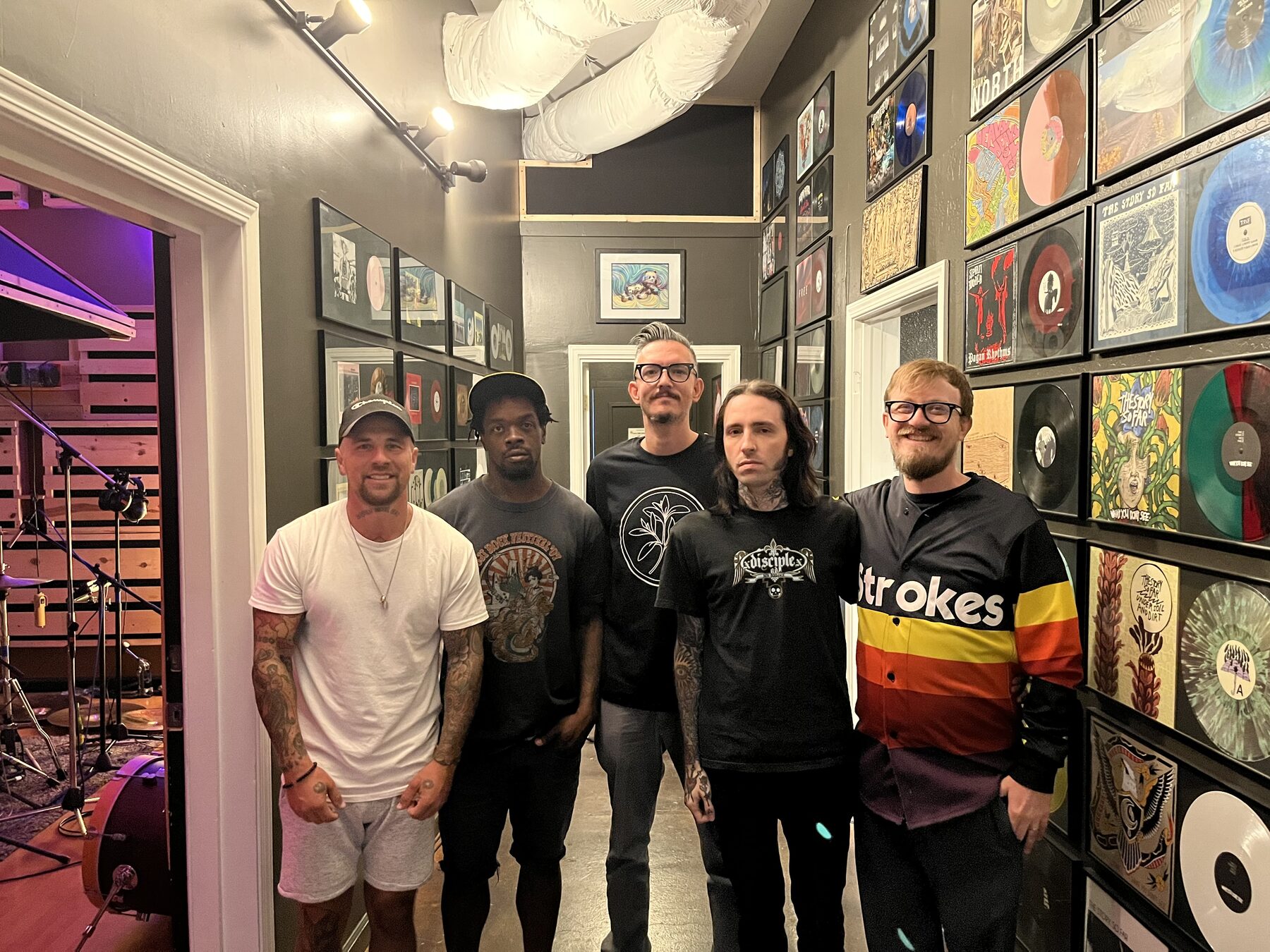 Group photo at The Panda Studios in front of the vinyl wall